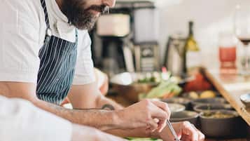 Un chef preparando comida en una cocina con varios platos y utensilios de cocina.