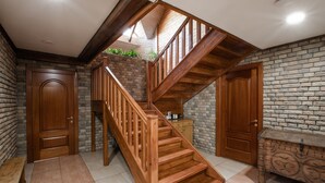 A wooden staircase with a brick wall backdrop, a bench, and a door. - Maietok Lis i Gory (Polyanitsya)