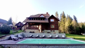 A wooden cabin with a swimming pool and lounge chairs. - Maietok Lis i Gory (Polyanitsya)