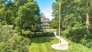 A large house surrounded by lush greenery and a well-maintained lawn. - MASSIVE Oceanfront Dark Harbor Home on ISLESBORO (Islesboro)