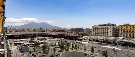A modern urban square with a central circular plaza, surrounded by buildings and a mountain in the background.