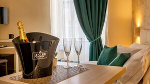 A hotel room with a minibar, a bed, a desk, and a window with curtains. - Re Diego (Naples)