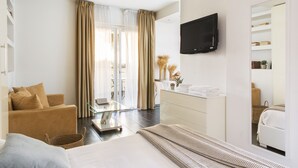 Una habitación de hotel moderna con cama, sofá, escritorio y televisor.