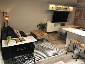 A modern living room with a sofa, coffee table, and a TV.