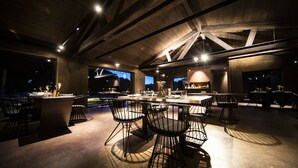 A modern interior with a bar area, seating, and large windows. - Hotel Les Pardines 1819 (Encamp)