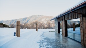 A wooden building with large windows and a snow-covered landscape in the background. - Hotel Les Pardines 1819 (Encamp)