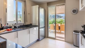 A modern kitchen with a refrigerator, sink, and a view of the outdoors.