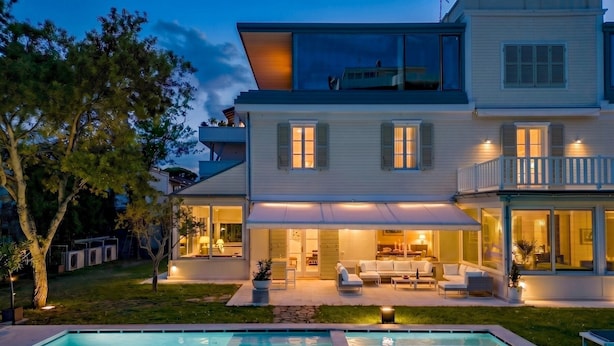 A modern two-story house with a swimming pool, outdoor seating, and a well-lit patio area. - Villa Guidi 10, Emma Villas (Cervia)