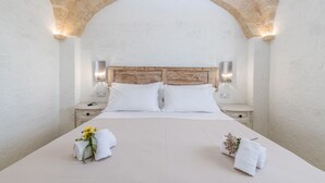 A bedroom with a large bed, two nightstands, and a stone archway. - Villa Gialonia 8+2, Emma Villas (Salve)