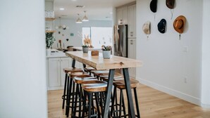 A modern kitchen with a central island, bar stools, and a ceiling fan. - Luxury 5BR Old Town Villa with Heated Pool & Games (Scottsdale)