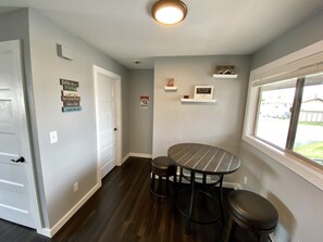 Enjoy a room with a round table, window view, and a shelf displaying local items.