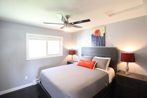 Relax in this serene bedroom with a comfortable bed, ceiling fan, and natural light pouring in through the window.