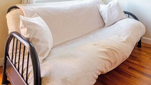 Una habitación acogedora con una cama individual, una ventana con cortinas y un cuadro enmarcado en la pared.