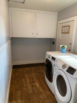 A laundry room with a washing machine, a dryer, and a cabinet above the washing machine. - Japanese-Style Retreat: Fountain, Hot Tub, Arcade (Chico)