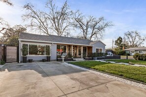 A modern two-story house with a covered patio, a driveway, and a well-maintained lawn. - Japanese-Style Retreat: Fountain, Hot Tub, Arcade (Chico)