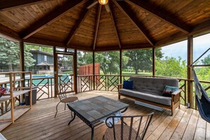 A covered outdoor area with a wooden deck, a sofa, a table, and chairs. - A Room with a View (Verona)
