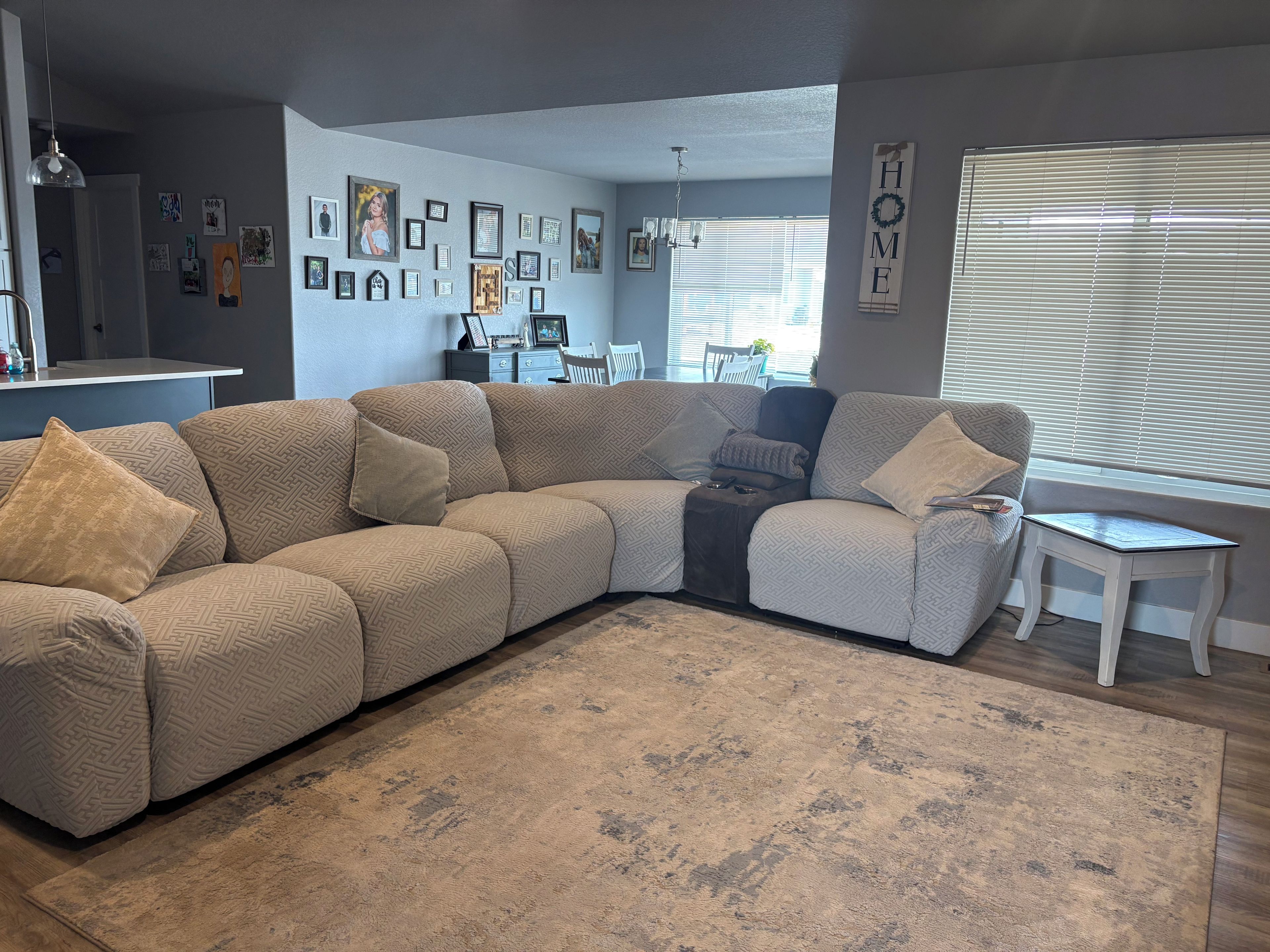 A living room with a sectional sofa, a coffee table, and a rug.