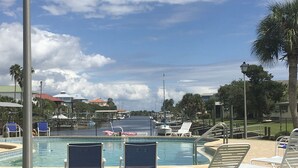 Un área de piscina con sillas de descanso y un pequeño bote.