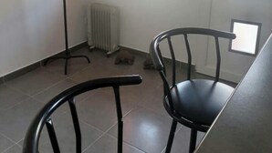 A room with two black chairs, a radiator, and a painting on the wall. - Ideal apartment for three people (Cerbère)