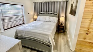 A bedroom with a bed, bedside lamps, a ceiling fan, and a window with blinds. - Cozy Cottage - Close to Everything, Nature Lovers Dream! (Odessa)