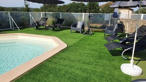 A swimming pool with artificial grass, lounge chairs, and umbrellas. - Comfortable 8-person house with shared heated pool between Sarlat and Cahors (Salviac)