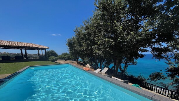 A clear blue swimming pool with lounge chairs and a view of the sea. - Villa on the Sea with pool and direct descent to the beach (Parghelia (Tropea))