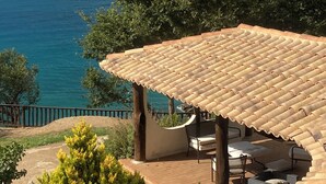 A covered outdoor seating area with a tiled roof, overlooking a coastal view. - Villa on the Sea with pool and direct descent to the beach (Parghelia (Tropea))