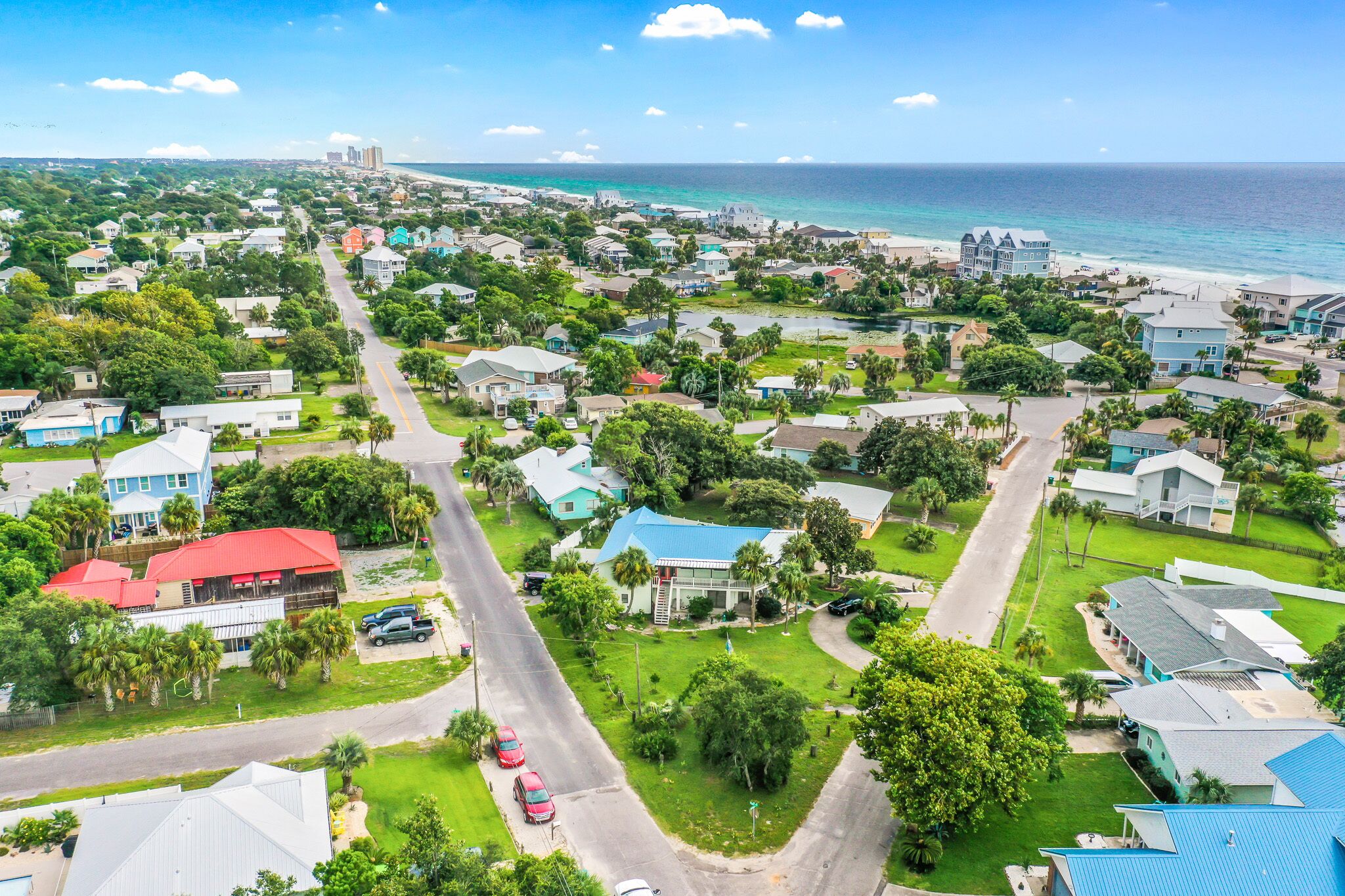Vista aérea de una zona residencial costera con casas, calles y una playa.