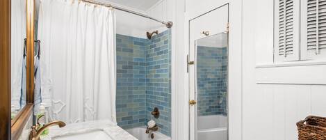 A bathroom with a white sink, a glass-enclosed shower, and a white toilet.
