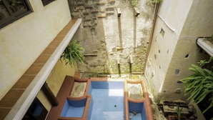 A courtyard with a blue pool, terracotta planters, and potted plants. - Hotel Maya Ik (Antigua Guatemala)
