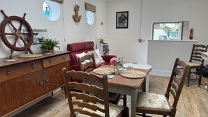 Un comedor con una mesa de madera, sillas y un sofá rojo.