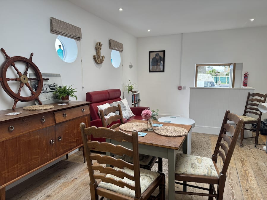 Un coin repas avec une table en bois, des chaises et un canapé rouge.