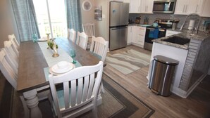 A modern kitchen with white cabinets, a stainless steel refrigerator, and a built-in oven. - Beachfront condo w Sunrise and Sunset Views (Surfside Beach)