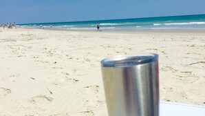 Un vaso metálico sobre una superficie blanca con un logotipo que dice 'Atlantic Beach'.