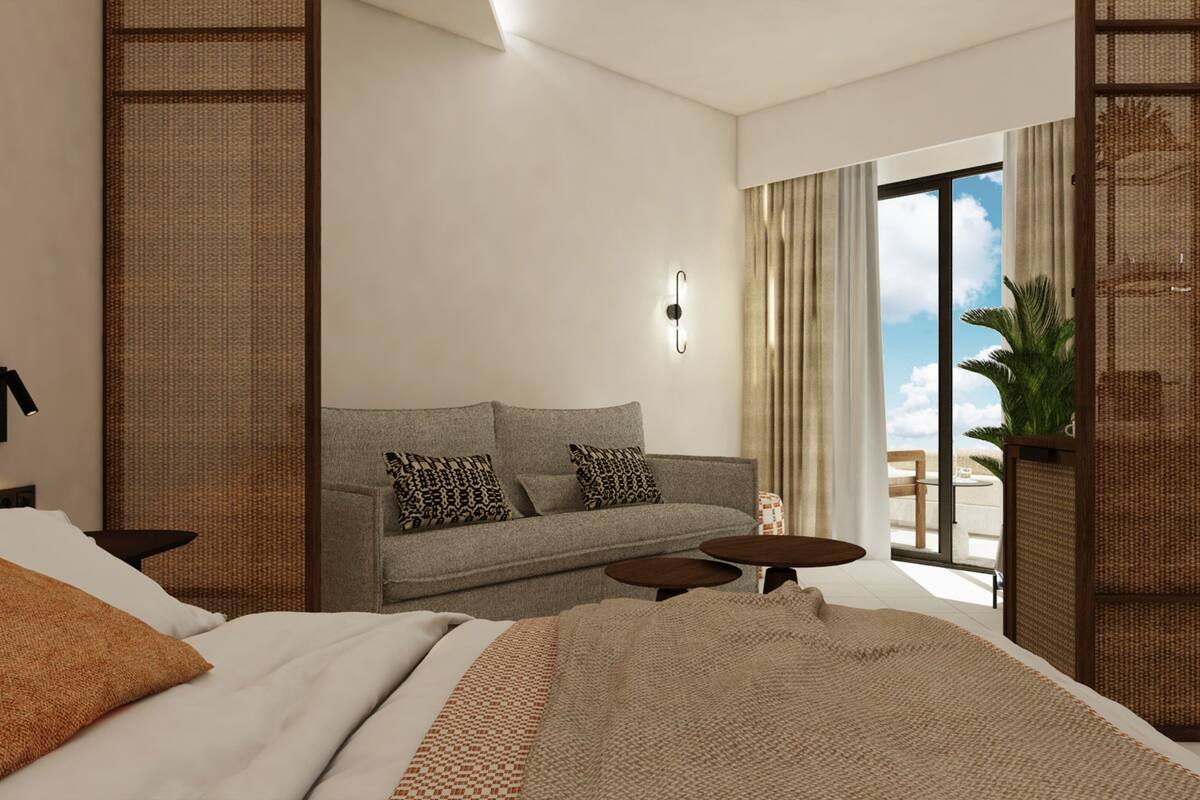 Una habitación de hotel moderna con cama, sofá, una mesita y un balcón con vistas.