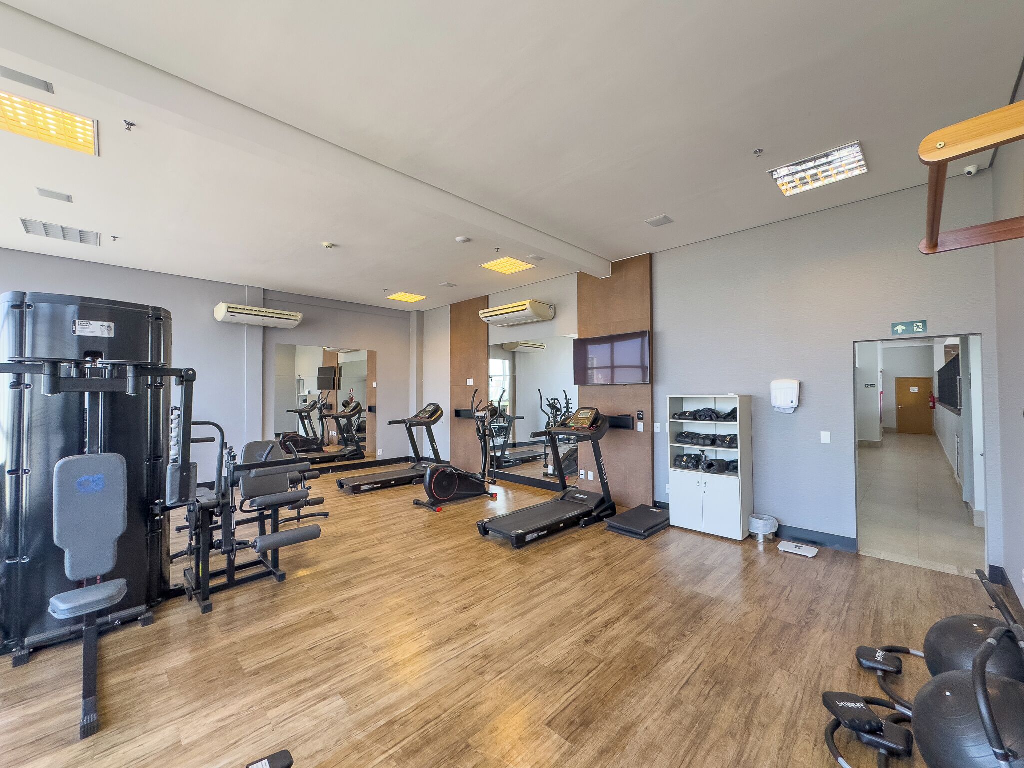 A gym with various exercise equipment, including treadmills, weight machines, and free weights.