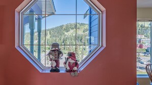 Una habitación con un amplio ventanal de forma octogonal con vistas a un paisaje montañoso.