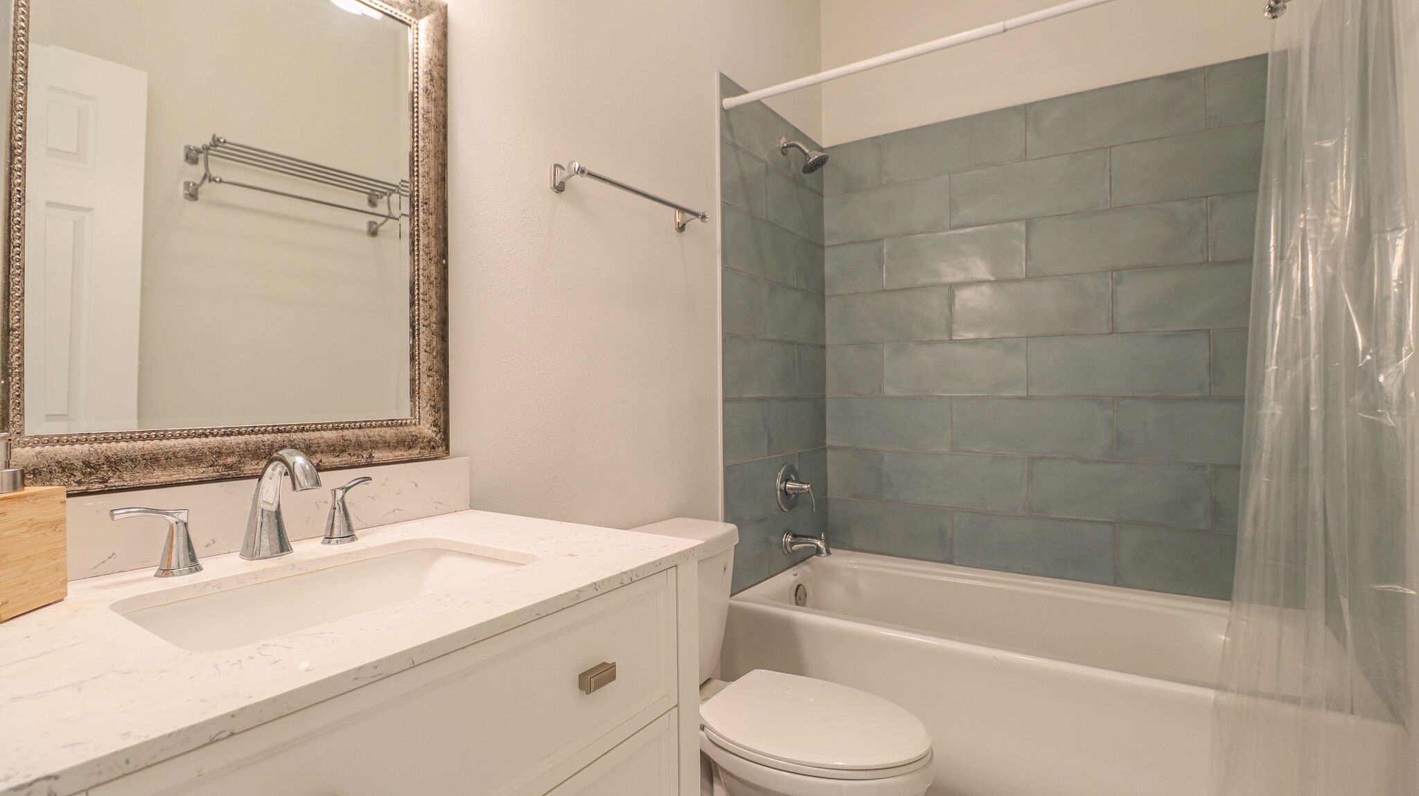 Een badkamer met een witte wastafel, een spiegel, een bad en een toilet.