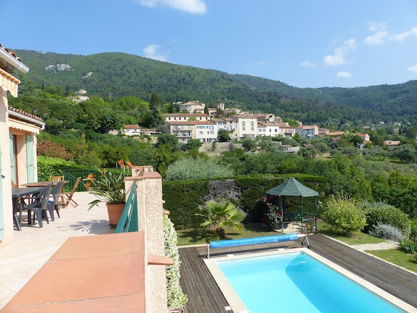 A pool area with a view of a hillside village.