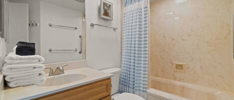 Ein modernes Badezimmer mit Waschbecken, Spiegel, Handtuchhalter und einer Duschvorhang.