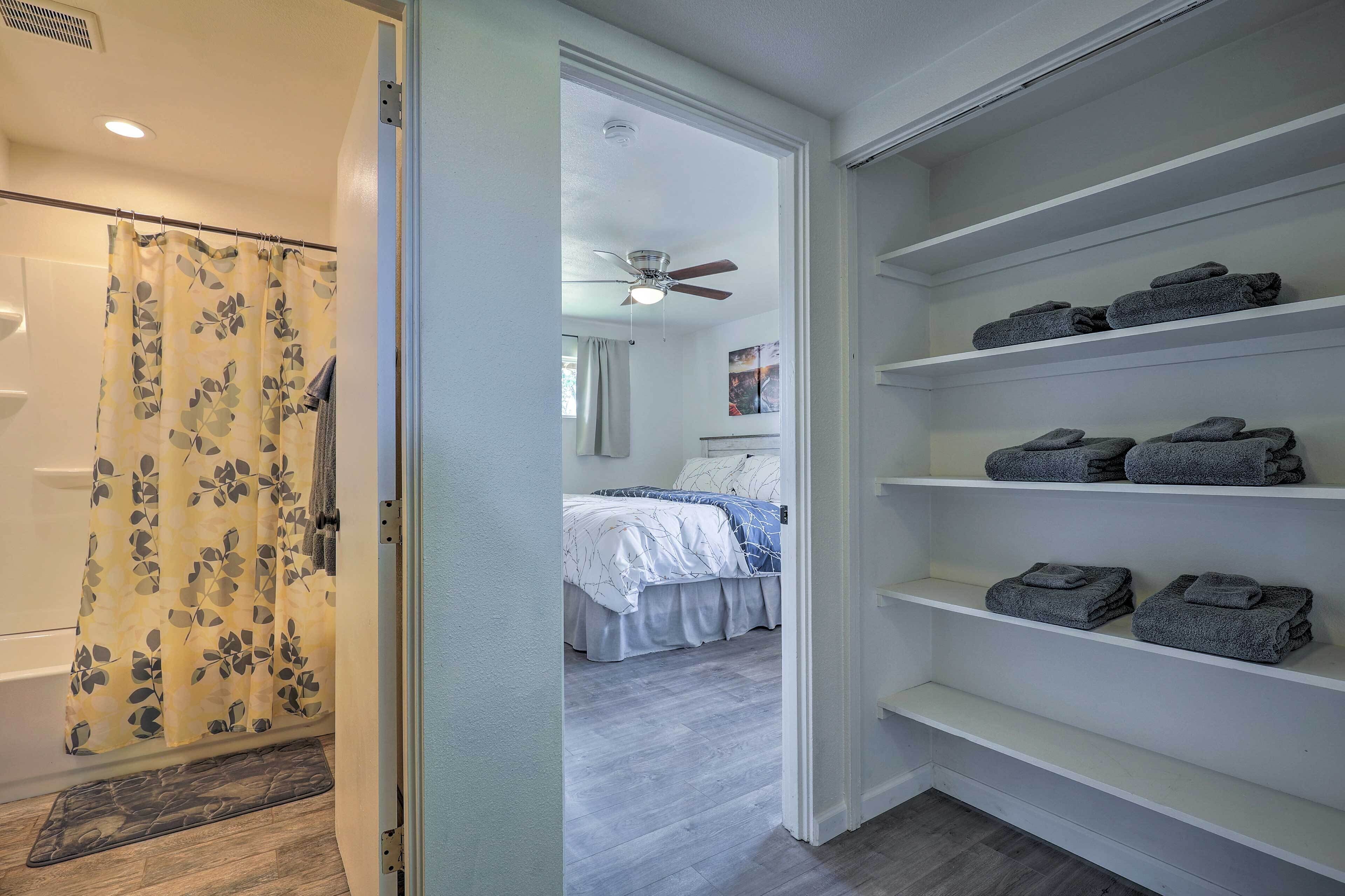 Un dormitorio con cama, ventilador de techo y baño con cortina de ducha.