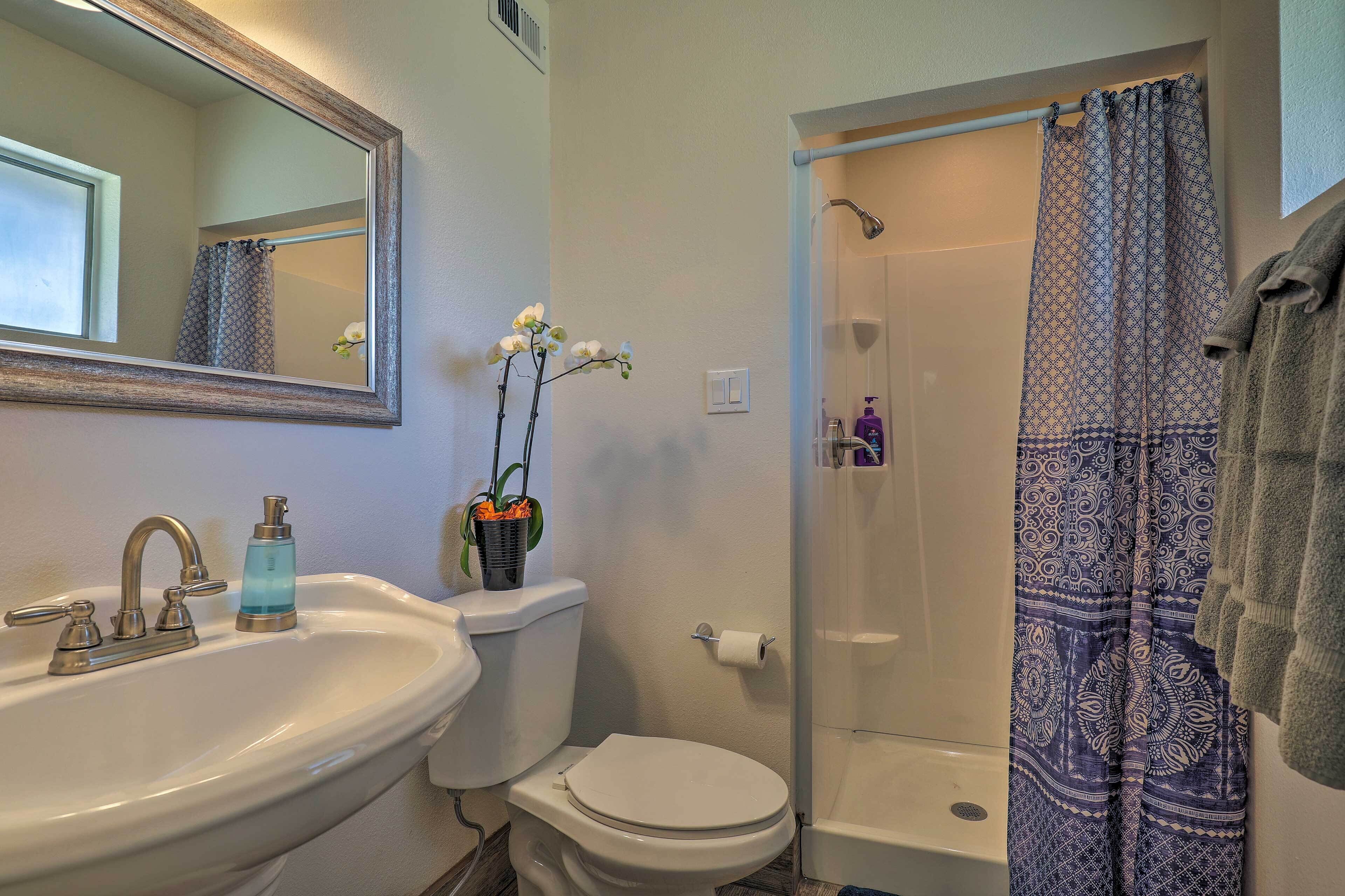 A bathroom with a sink, toilet, and shower.