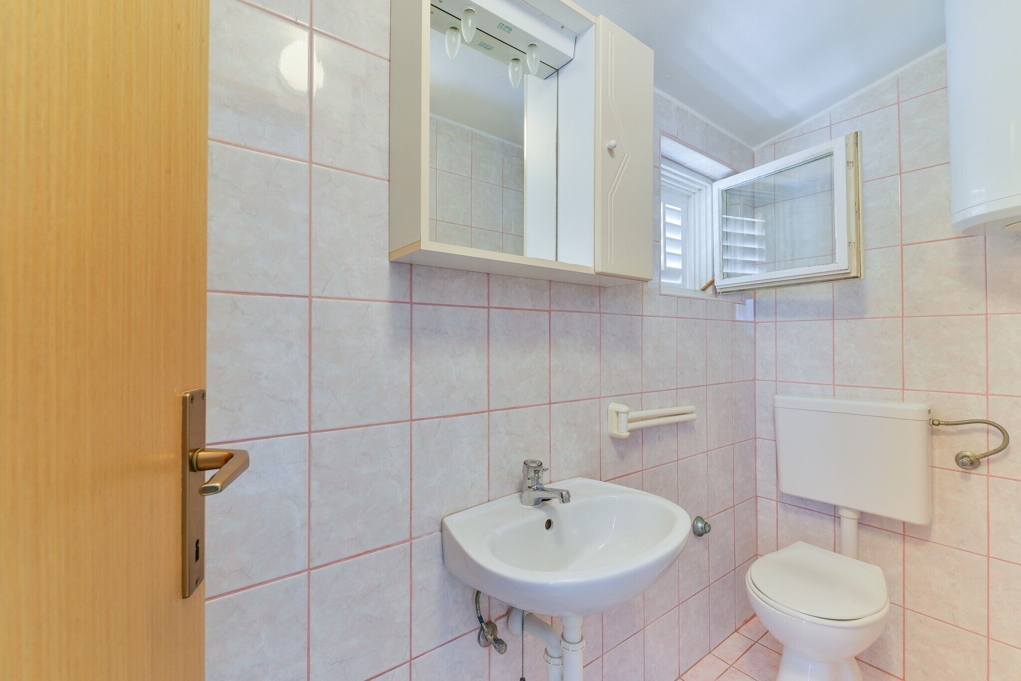 Une salle de bain avec un lavabo, des toilettes et un miroir.