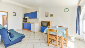 A compact living space with a kitchenette, a dining area, and a sofa. - Summer Dream - One Bedroom Apartment with Sea View (Privlaka)
