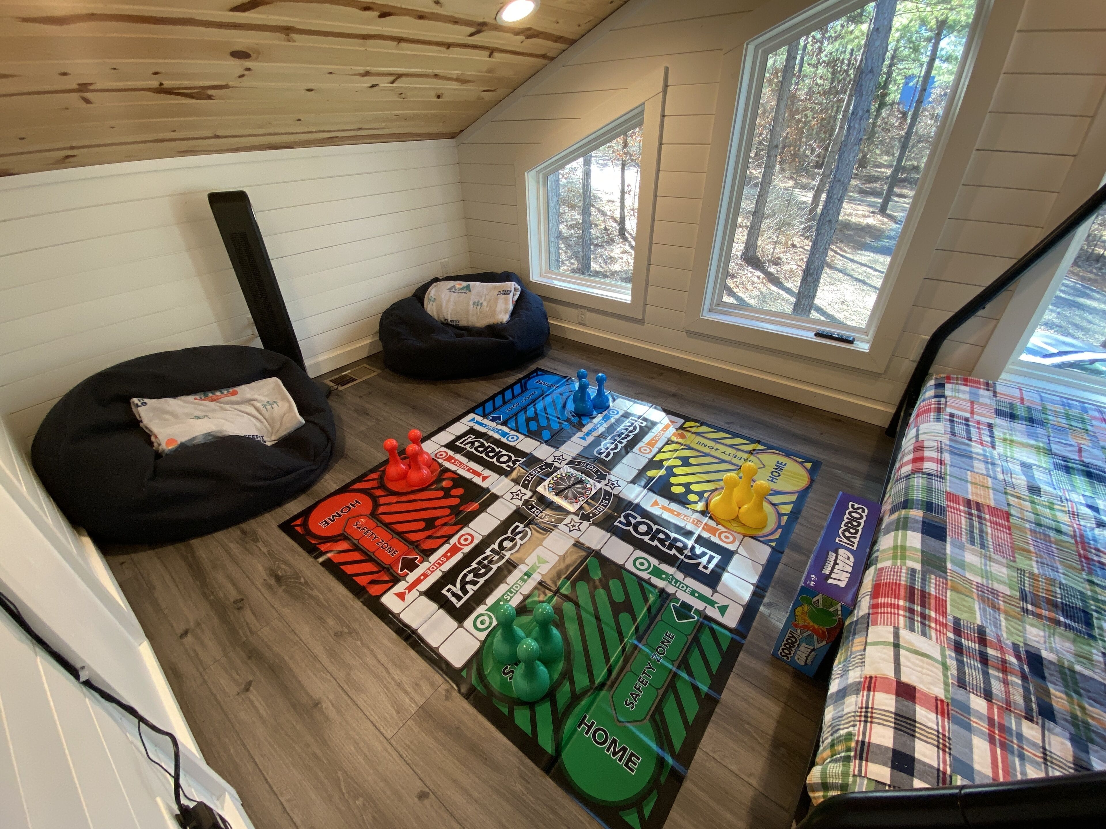 A cozy room with a board game, bean bags, and a view of trees.
