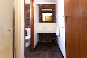 A bathroom with a white sink, a mirror, and a toilet.
