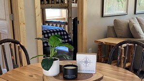 A wooden round table with chairs, a potted plant, a candle, and a compass sign. - Newly Renovated Cabin -dog friendly (Tomahawk)