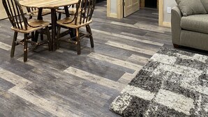 A compact room with a wooden dining table and chairs, a gray sofa, and a patterned rug. - Newly Renovated Cabin -dog friendly (Tomahawk)