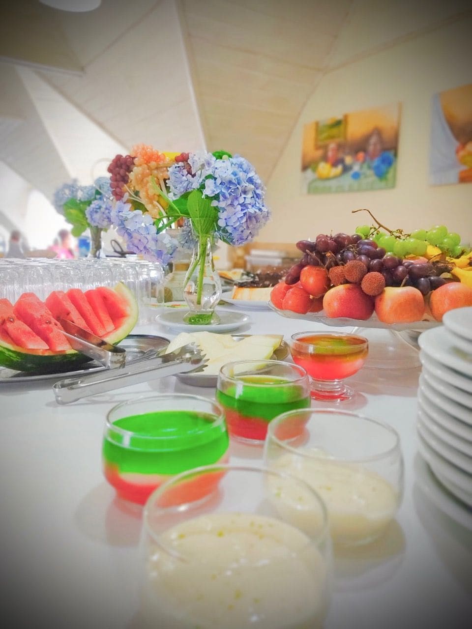 A buffet table with various food items and a vase of flowers.