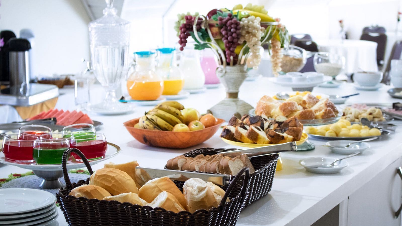 Un bufé de desayuno con diversas opciones de comida, como pan, frutas y bebidas.